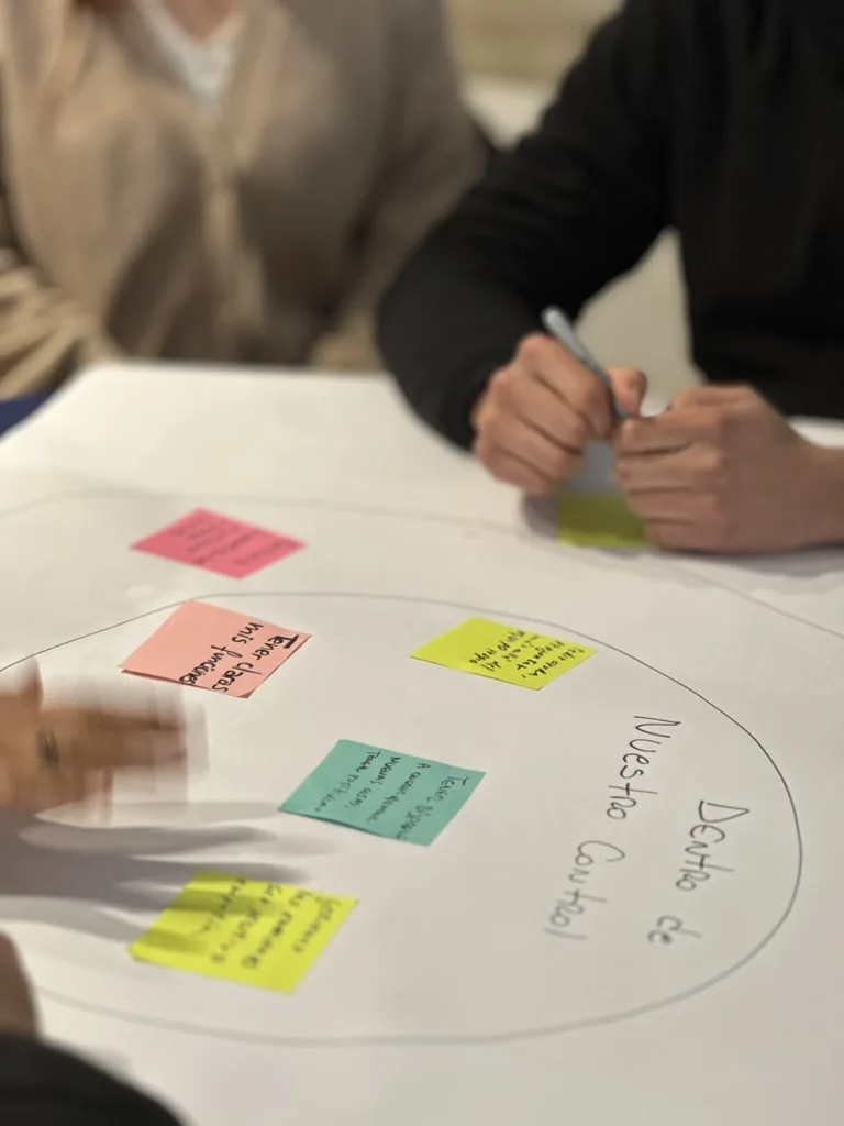 Trabajo colaborativo con notas y materiales sobre una mesa