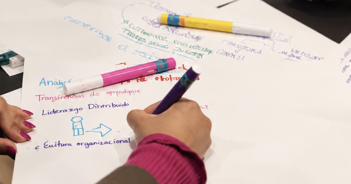 Persona escribiendo «cultura organizacional» en un papelógrafo durante un taller